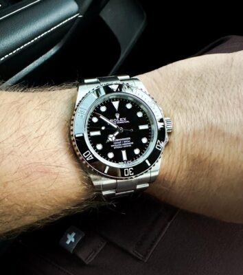 Rolex Submariner on wrist in car review image