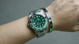Close-up of Absinthe GMT Two-Tone Bracelet watch with vibrant green and black bezel on a man's wrist, premium titanium steel bracelet