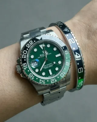 Close-up of Absinthe GMT Two-Tone Bracelet watch with vibrant green and black bezel on a man's wrist, premium titanium steel bracelet