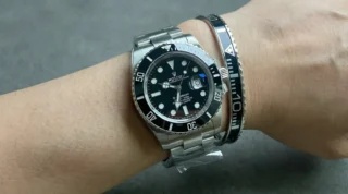 Close-up of Submariner Black Dial 126610LN watch with matte black dial and bezel on a man's wrist, premium titanium steel bracelet