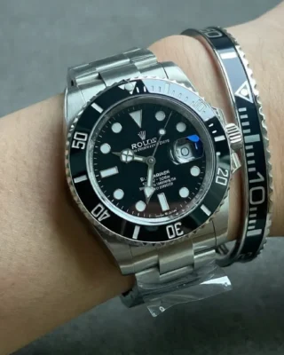 Close-up of Submariner Black Dial 126610LN watch with matte black dial and bezel on a man's wrist, premium titanium steel bracelet