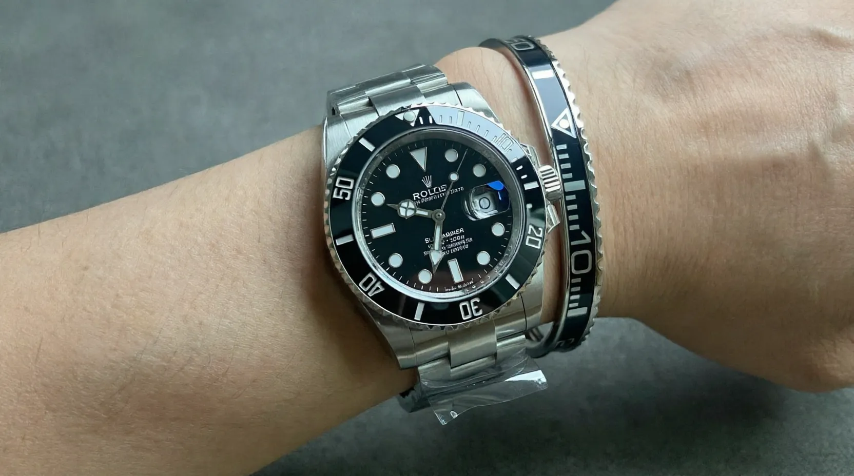 Close-up of Submariner Black Dial 126610LN watch with matte black dial and bezel on a man's wrist, premium titanium steel bracelet