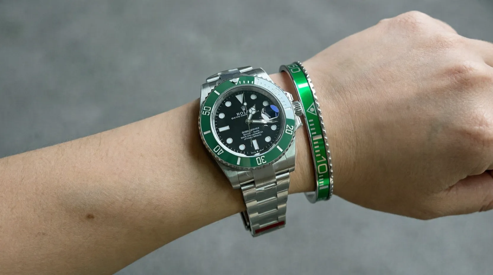 Close-up of Starbucks Green Submariner watch with vibrant green dial and bezel on a man's wrist, premium titanium steel bracelet