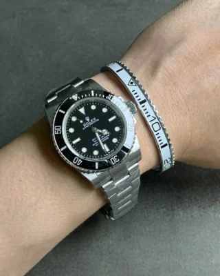 Close-up of Submariner Black Dial 124060 No-Date watch with clean white bezel on a man's wrist, premium titanium steel bracelet