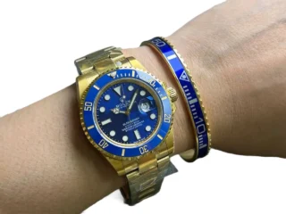 Blue Submariner Gold Tone Titanium Steel Bracelet on wrist with two-tone blue and gold Rolex Submariner watch