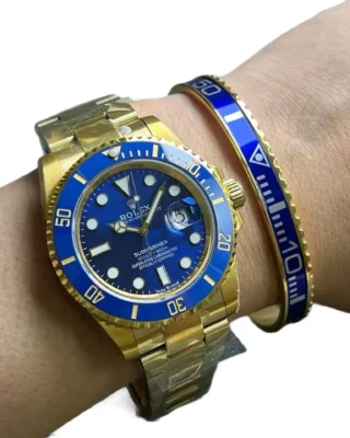 Blue Submariner Gold Tone Titanium Steel Bracelet on wrist with two-tone blue and gold Rolex Submariner watch